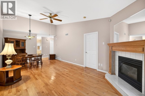 Kitchen with oak cabinets, white appliances, and checkered tile flooring. - 39 23580 Dewdney Trunk Road, Maple Ridge