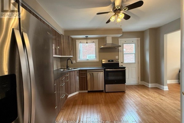 Modern kitchen with stainless steel appliances, wooden cabinetry, and hardwood flooring - 39 April Gardens, Aurora