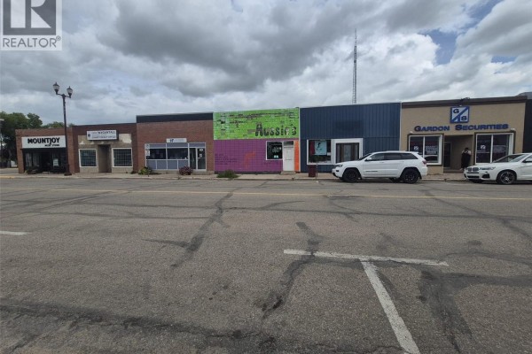 Street view of commercial storefronts including "Mountjoy", "Aussie's", and "Gardon Securities". - 39 Betts Avenue, Yorkton