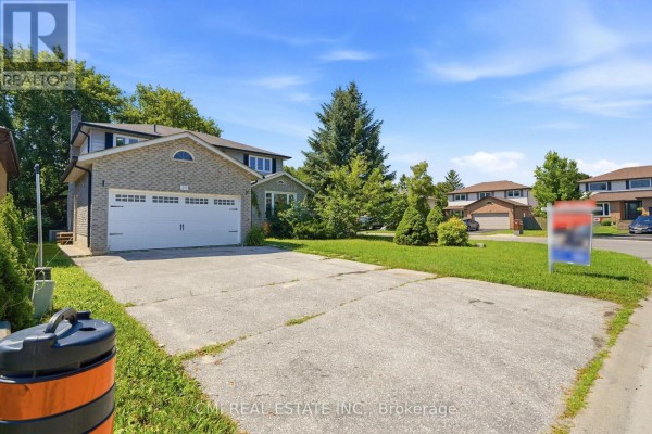 View of the side of the house showing a driveway and garage. - 39 Camrose Drive, Georgina