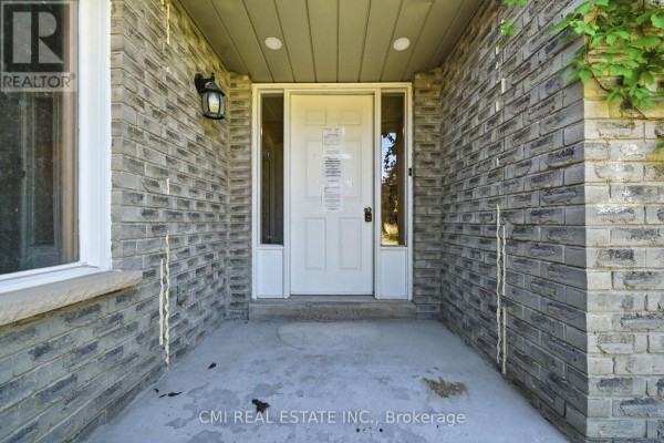 Close-up of the front door entrance with grey brick siding. - 39 Camrose Drive, Georgina