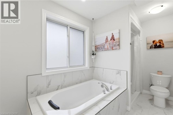 Bathroom with soaking tub, shower, toilet, and marble tiles - 39 Dunning Way St, St. Thomas