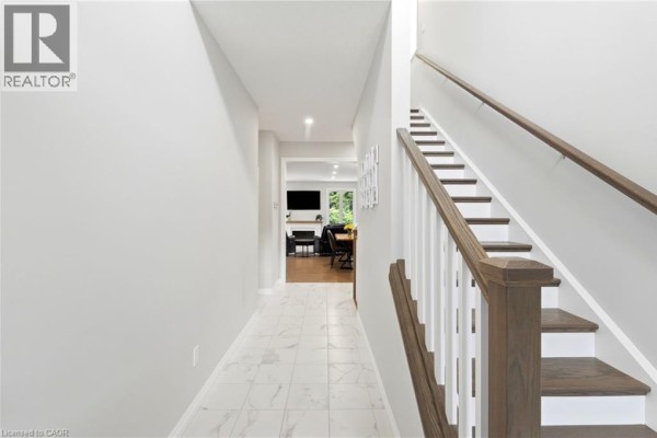 Entrance foyer with a white front door, a round mirror, and a console table with plants. - 39 Dunning Way, St  Thomas