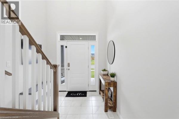 Open concept living, dining, and kitchen area with white cabinets, stainless steel appliances, and hardwood floors. - 39 Dunning Way, St  Thomas