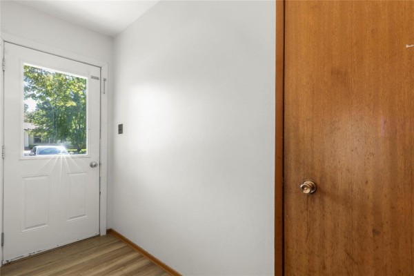 Interior entryway with a white door, a full-length window, and a natural wood closet door. - 39 First Avenue N, Blumenort