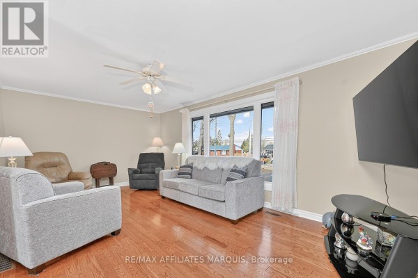 Living room with hardwood floors, sofa, armchairs, and large window - 39 Golf Club Road Rideau Lakes
