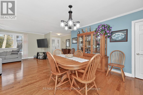 Wooden dining set and hutch in open-concept dining room next to living area - 39 Golf Club Road Rideau Lakes