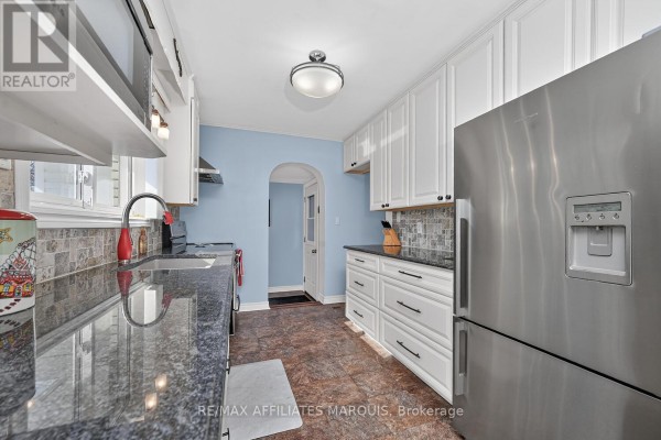 Kitchen with stainless steel refrigerator, granite counters, and white cabinets - 39 Golf Club Road Rideau Lakes