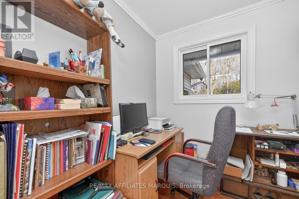 Office with bookshelves, desk, computer, and chair - 39 Golf Club Road Rideau Lakes