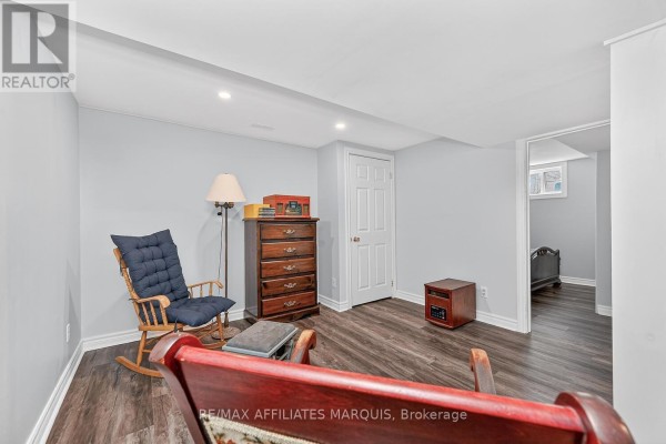 Rocking chair, dresser, and bed in a room with dark wood floors - 39 Golf Club Road Rideau Lakes