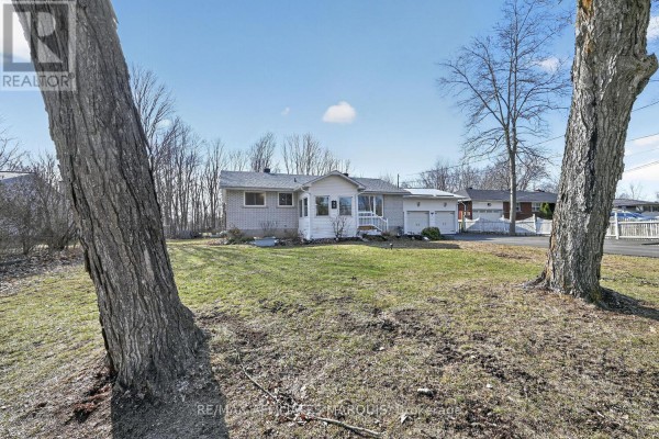 Single-story brick house with attached garage and sunroom - 39 Golf Club Road Rideau Lakes