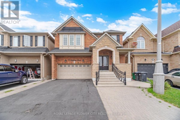 Front exterior of 39 Hadfield Circle, a brick and stone house with a double garage. - 39 Hadfield Circle, Brampton