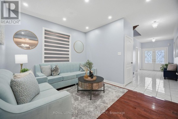 Living room of 39 Hadfield Circle with light blue walls, hardwood floors, and light blue sofas. - 39 Hadfield Circle, Brampton