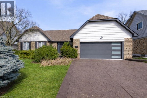 Front view of the house featuring a stone and siding exterior with a double garage. - 39 Hilts Drive, Stoney Creek