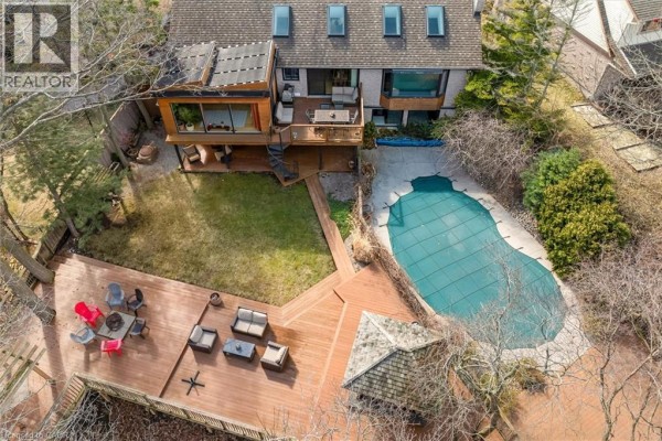 Aerial view of the backyard, pool, and deck area surrounded by trees. - 39 Hilts Drive, Stoney Creek