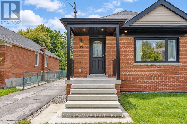 Close-up of the front entrance with concrete steps, black railings, and a glass-paned door. - 39 Janet Boulevard, Toronto