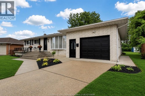 Driveway and attached garage with a black door on a white brick house. - 39 Johnson Avenue, Leamington