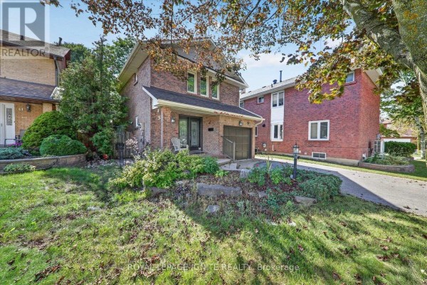 Front view of the brick house with a covered porch and surrounding greenery. - 39 Longfellow Court, Whitby