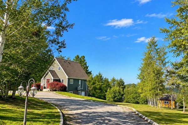 A dark green house with a red front door sits at the top of a curving gravel driveway. - 39 Main Road, Town Of Terra Nova