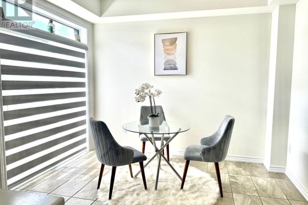 Living room with hardwood floors, black leather sofa, armchairs, coffee table, and television. - 39 Prudhoe Terrace, Barrie
