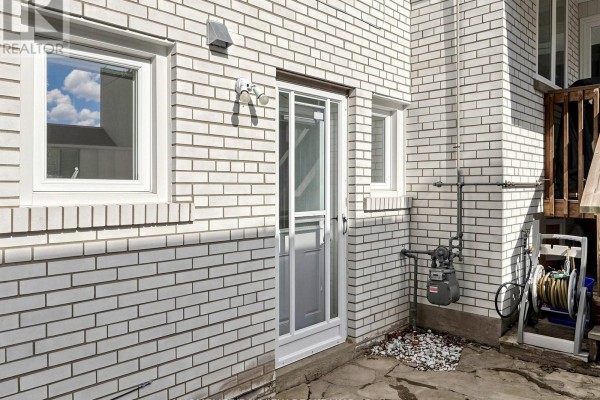 Interior hallway with white door, tile floor, and coat hooks on pale blue walls. - 39 Shenstone(basement) Road, Toronto