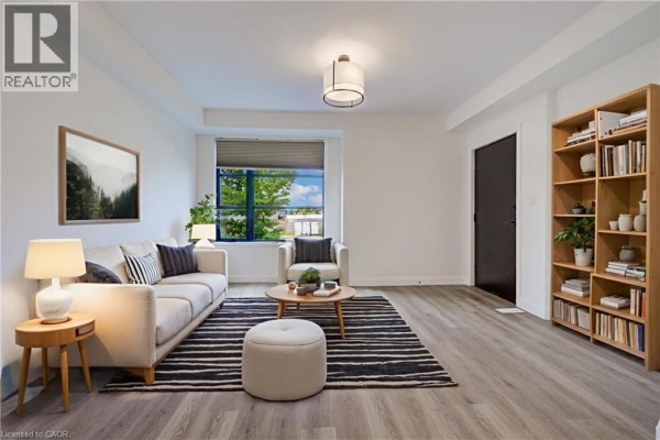 Living room with beige sofa, armchair, round coffee table, and striped rug. - 3900 Savoy Street Unit# 15, London