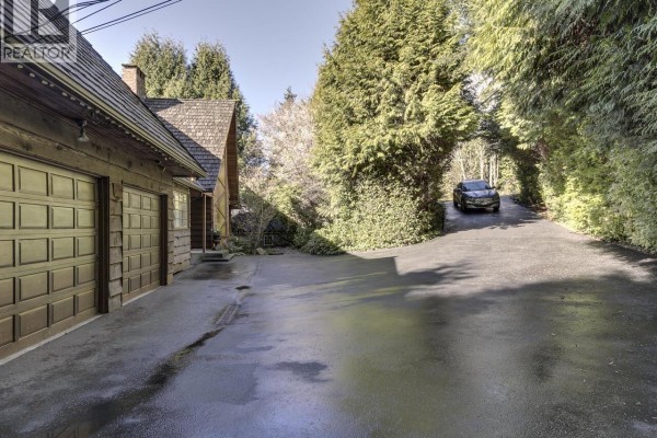 Driveway view with attached garage and surrounding greenery - 3904 Westridge Avenue, West Vancouver