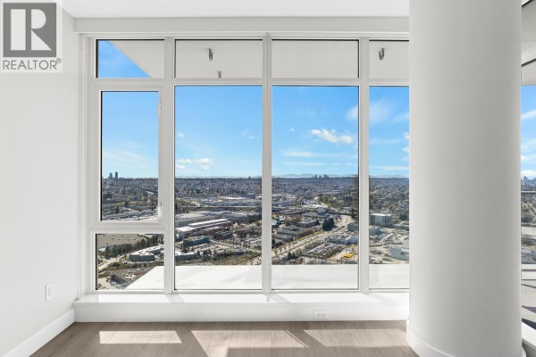 Panoramic city view through large white-framed windows in a modern apartment. - 3905 1788 Gilmore Avenue, Burnaby