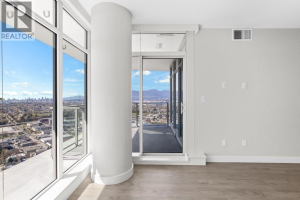 Balcony access from the living area with city and mountain views through glass doors. - 3905 1788 Gilmore Avenue, Burnaby