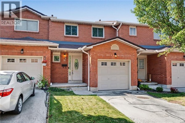 Front exterior of a brick townhouse with a single garage door and landscaped lawn. - 391 Stone Church Road E Unit# 14, Hamilton