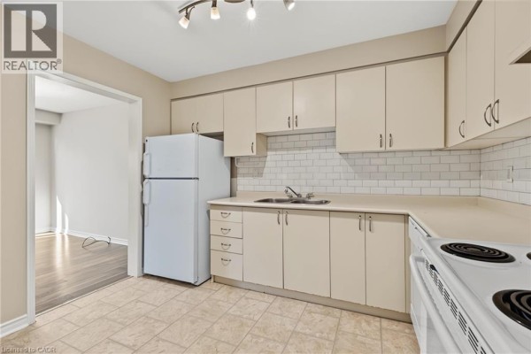 Kitchen with light beige cabinets, white countertops, white refrigerator, and white stove. - 391 Stone Church Road E Unit# 14, Hamilton