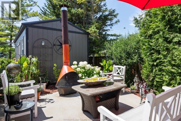 Outdoor patio with wicker furniture, metal fireplace, and white hydrangea bushes. - 3914 St. Clair Road, Stoney Point