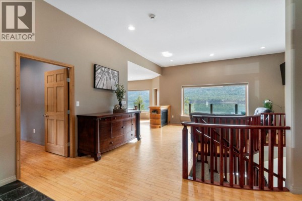 Dining area with a round wooden table, chairs, built-in cabinetry, and a large window with a lake view. - 3918 Parri Road, Sorrento