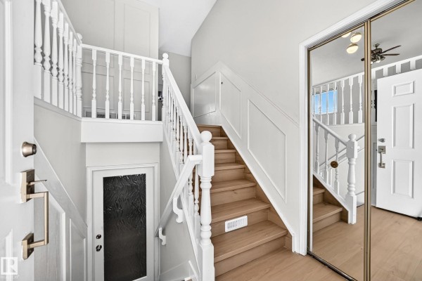 Interior staircase with white banisters and light wood flooring. - 3924 26a Av Nw, Edmonton