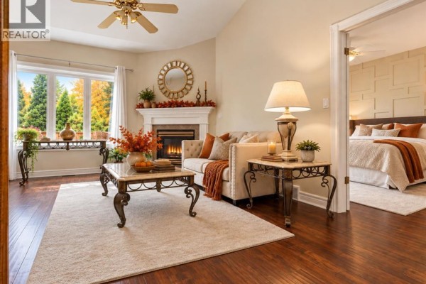 Primary bedroom with a king-size bed, dresser, nightstands, and access to a balcony. - 393 Tuscany Crescent, Tecumseh