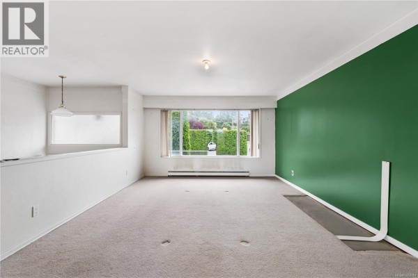 Interior view of a staircase with beige carpet and a black metal railing. - 3931 Braefoot Pl, Saanich