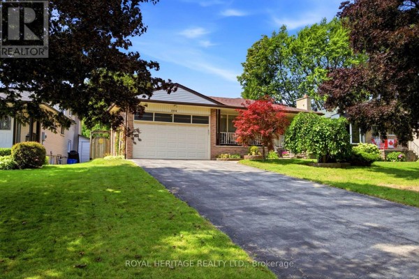 View of the house from the driveway, showcasing the attached garage and front entrance. - 394 Amstel Court, Oshawa