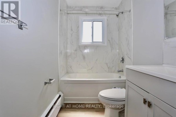 Bathroom featuring marble walls, bathtub, and window for natural light - 394 Thiel Street, London East