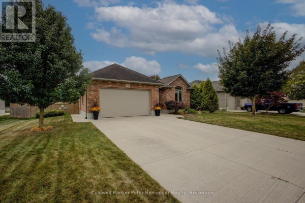 View of the brick house from the driveway, highlighting the garage and landscaping. - 395 3rd Street S, Hanover