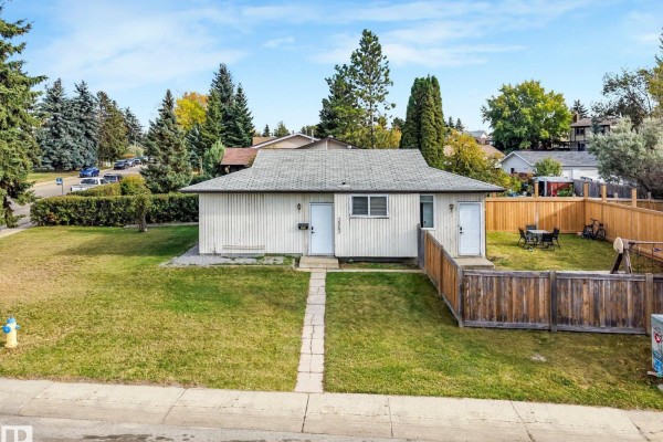Front exterior of a modest bungalow with two separate entrances and a grassy front yard. - 3963 57 St Nw, Edmonton