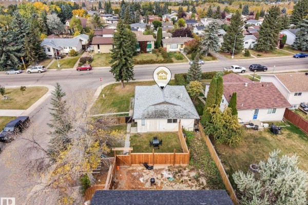 Overhead shot of the backyard with a wooden fence, patio furniture, and green lawn. - 3963 57 St Nw, Edmonton
