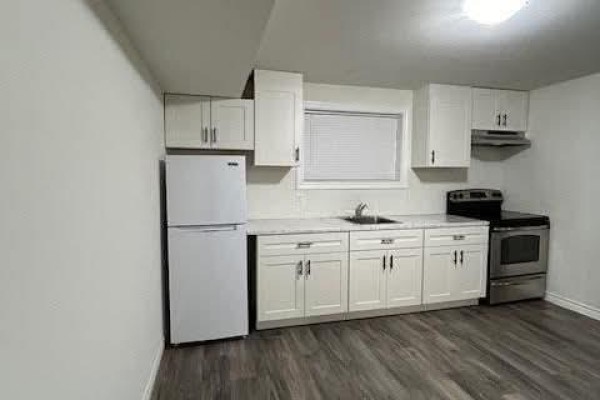 Compact kitchen with white cabinets, white appliances, and a window. - 397 Hemlock Lane Unit# Lower, Lakeshore