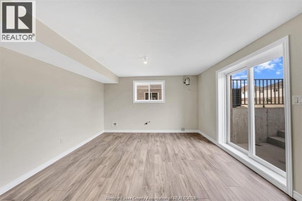 Living room with sliding glass doors opening to a concrete patio area. - 397 Hemlock Lane Unit# Lower, Lakeshore