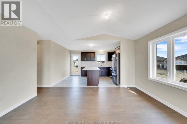 View from living area into an open kitchen with dark wood cabinets and a tiled floor. - 397 Hemlock Lane Unit# Main, Lakeshore