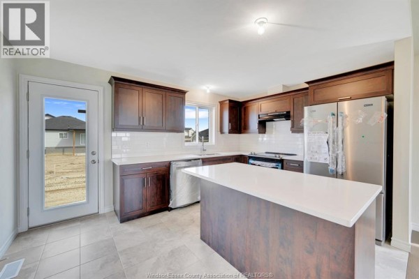 Kitchen featuring dark wood cabinets, white countertops, stainless steel appliances, and a center island. - 397 Hemlock Lane Unit# Main, Lakeshore