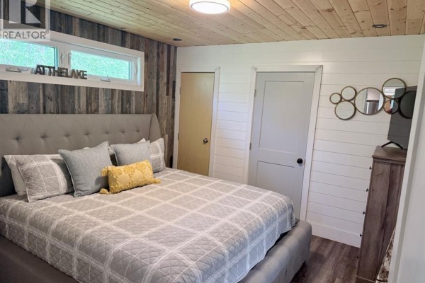 View through open front door to hallway with white paneled walls. - 398 68268 132a Range, Rural Lac La Biche County