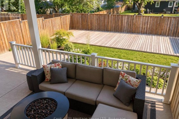 Aerial view of a backyard with a large wooden deck, a grassy area, and a pool. - 3984 Village Creek Drive, Fort Erie