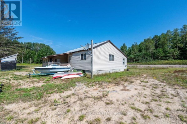 Rear view of the house with two boats on trailers in the yard. - 39869 Highway 17 Highway, Head, Clara And Maria