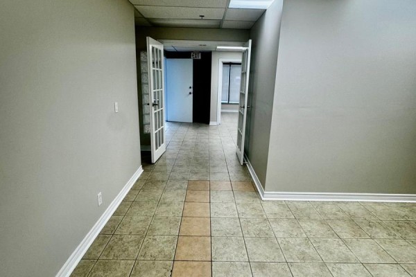 Interior hallway with tiled floor, beige walls, and double glass doors. - 3a - 400 Creditstone Road W, Vaughan
