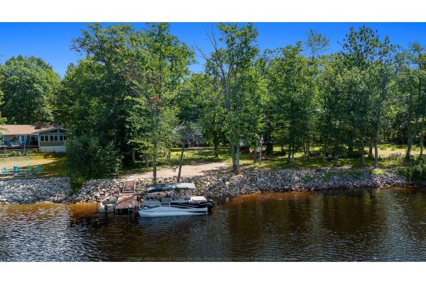 Aerial view of a waterfront property with a dock, boat, and trees lining the shore. - 3a Ch. Pearson, Mansfield Et Pontefract